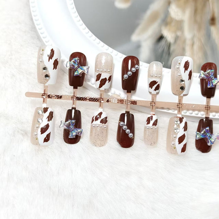 Artificial nails with sparkling rhinestone and bow accents Bowlift