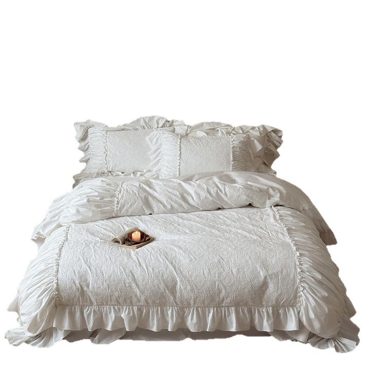 Romantic broderie anglaise bedding set with ruffle, quilted bedspread and decorative cushion