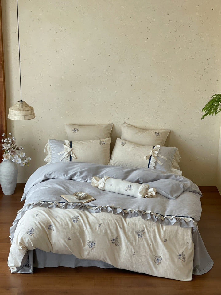 Romantic cotton satin bedding set with ruffles, embroidered flower bouquets, and decorative rolls Bowlift