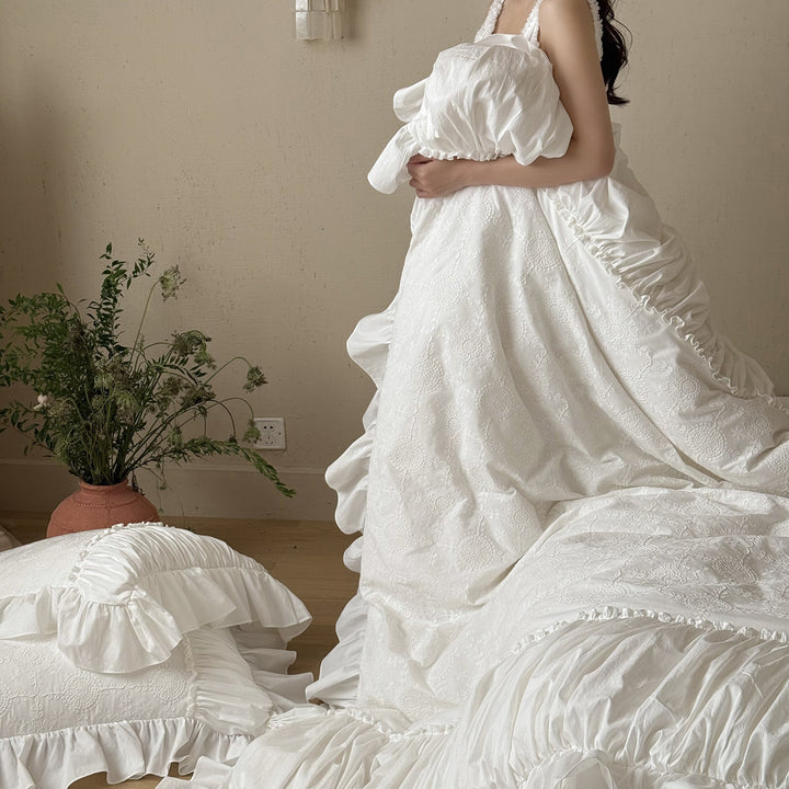 Romantic broderie anglaise bedding set with ruffle, quilted bedspread and decorative cushion