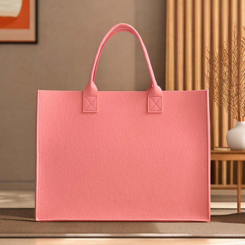 Structured felt tote bag with reinforced handles and organized interior Bowlift