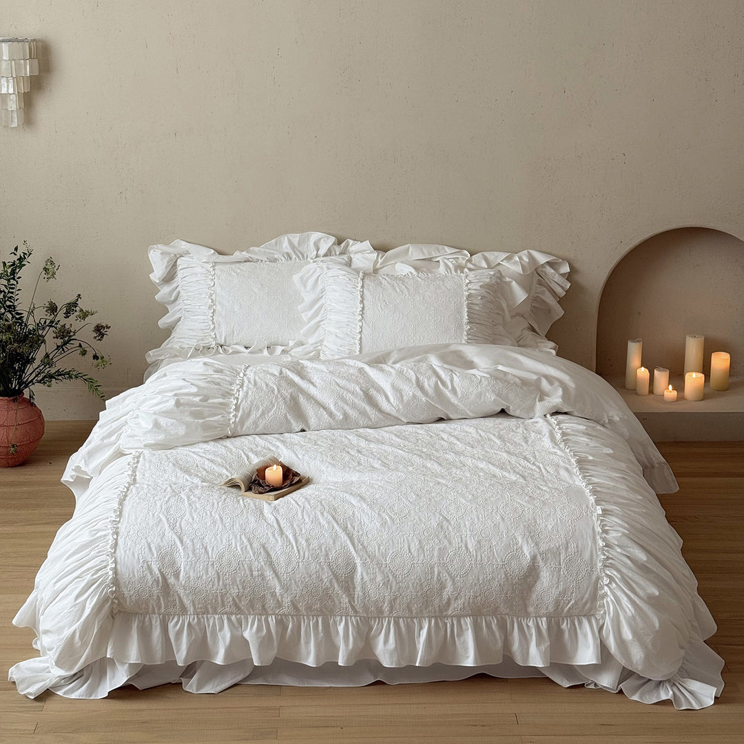 Romantic broderie anglaise bedding set with ruffle, quilted bedspread and decorative cushion