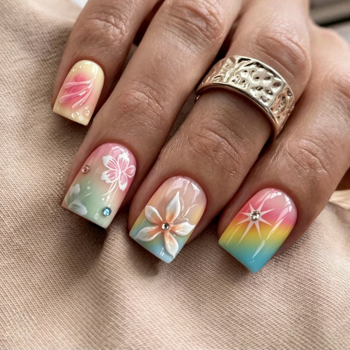 Artificial nails in vibrant floral design with glitter accents Bowlift