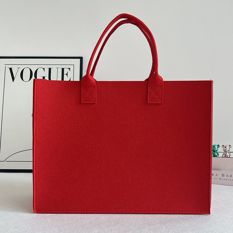 Structured felt tote bag with reinforced handles and organized interior Bowlift