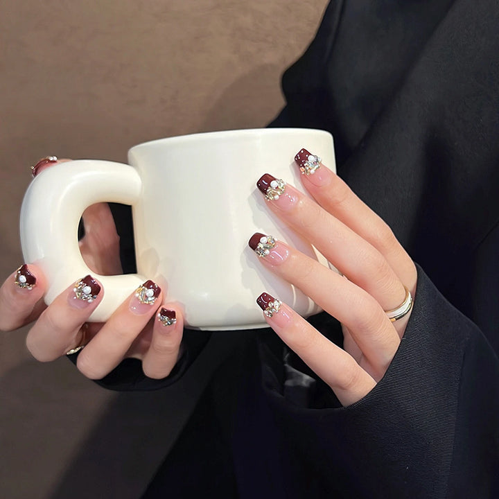 Glamorous artificial nails with decorative pearl and glitter embellishments Bowlift