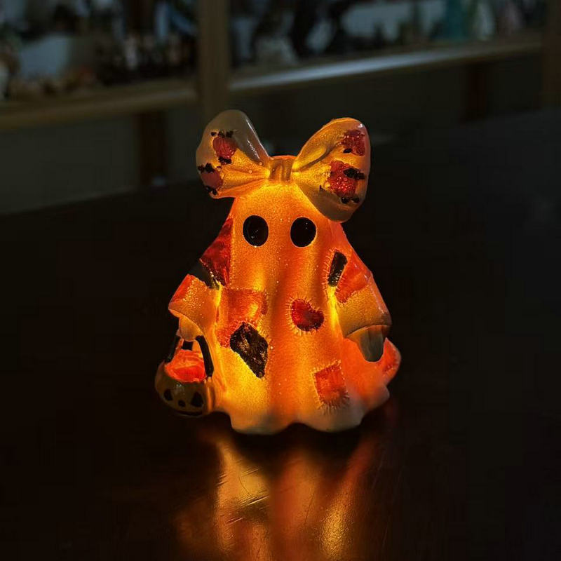 Ceramic ghost figure with integrated lighting and pumpkin basket