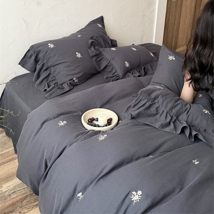 Cotton satin bedding set with delicate embroidered flowers, ruffled decorative pillow, and hotel closure Bowlift