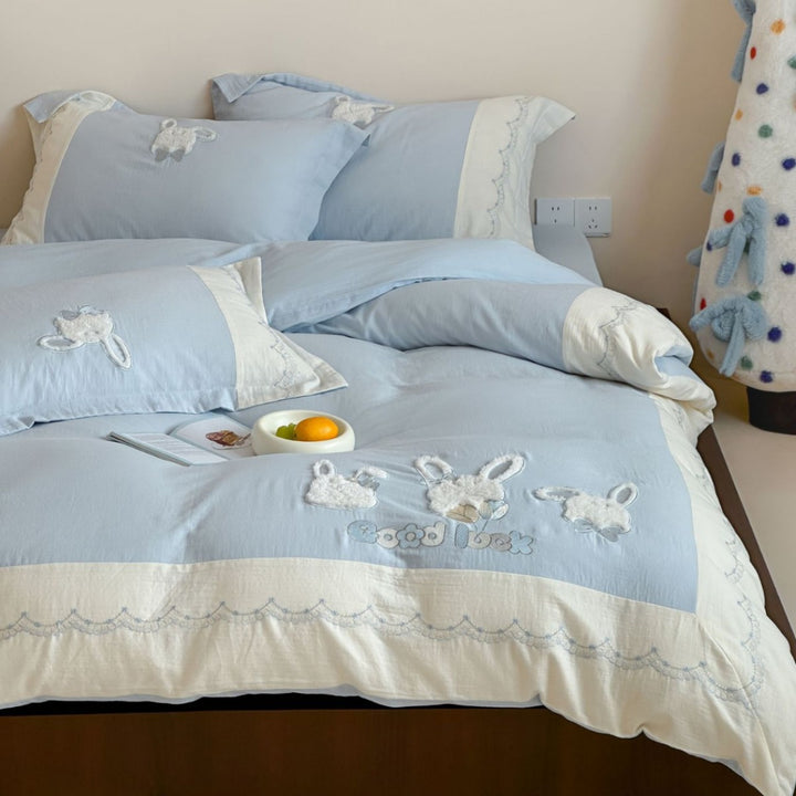 Embroidered cotton satin bedding set with appliquéd rabbit designs and decorative border