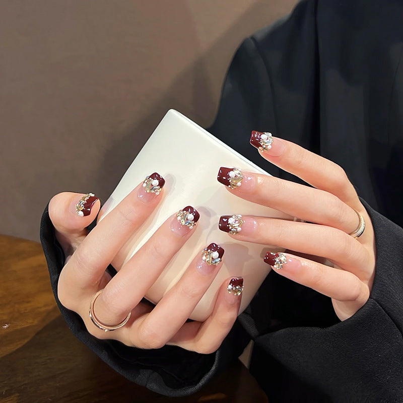 Glamorous artificial nails with decorative pearl and glitter embellishments Bowlift