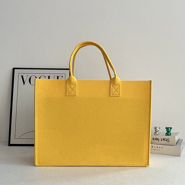 Structured felt tote bag with reinforced handles and organized interior Bowlift