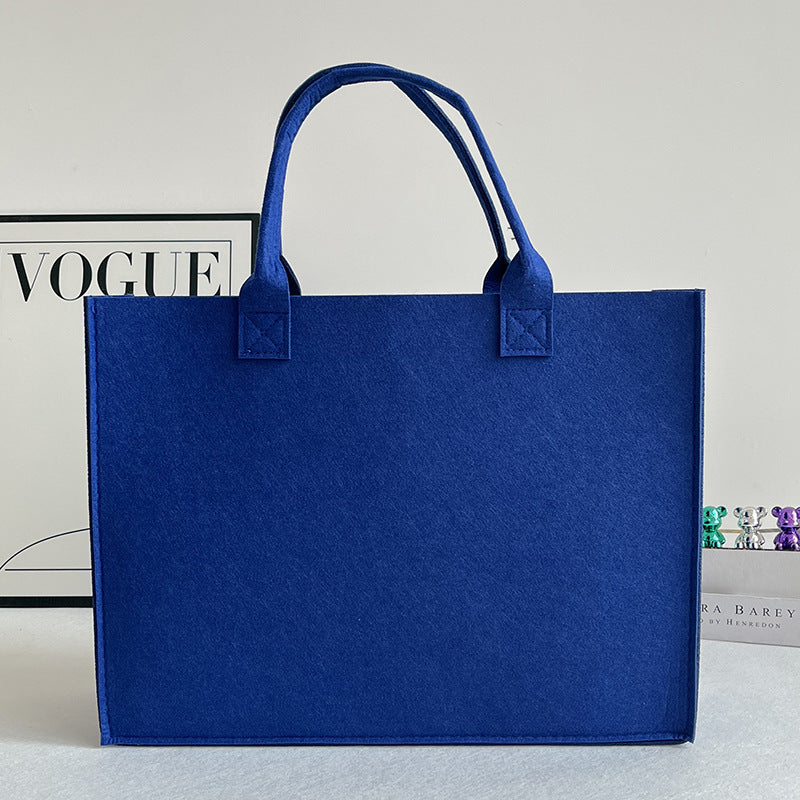 Structured felt tote bag with reinforced handles and organized interior Bowlift