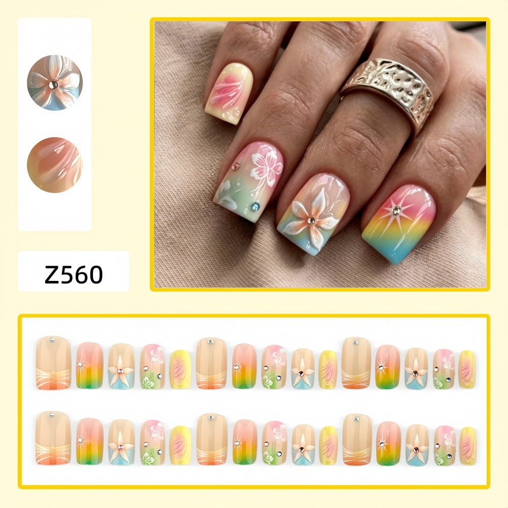Artificial nails in vibrant floral design with glitter accents Bowlift
