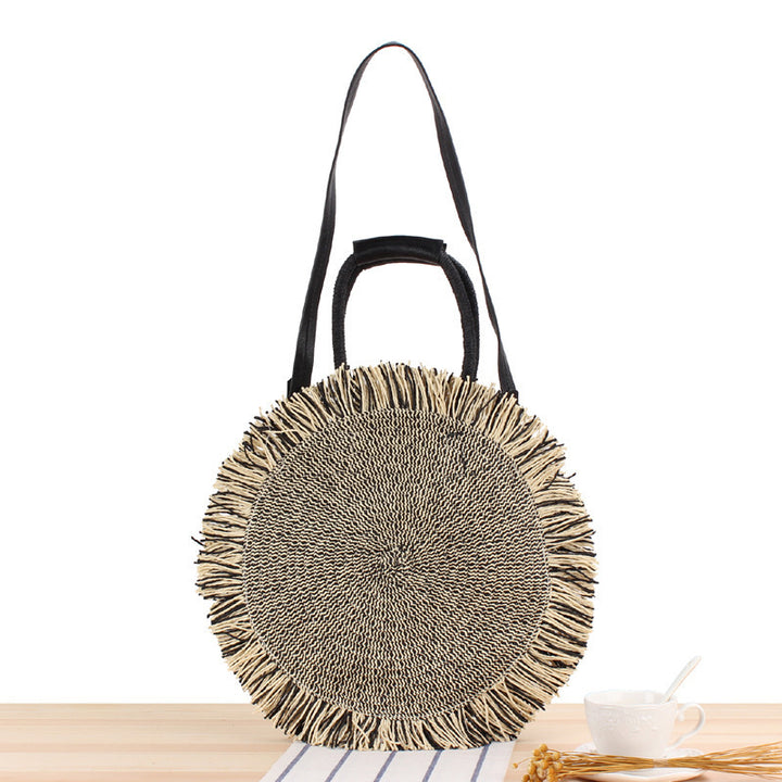 Round bag with fringe decoration Made of woven material Bowlift