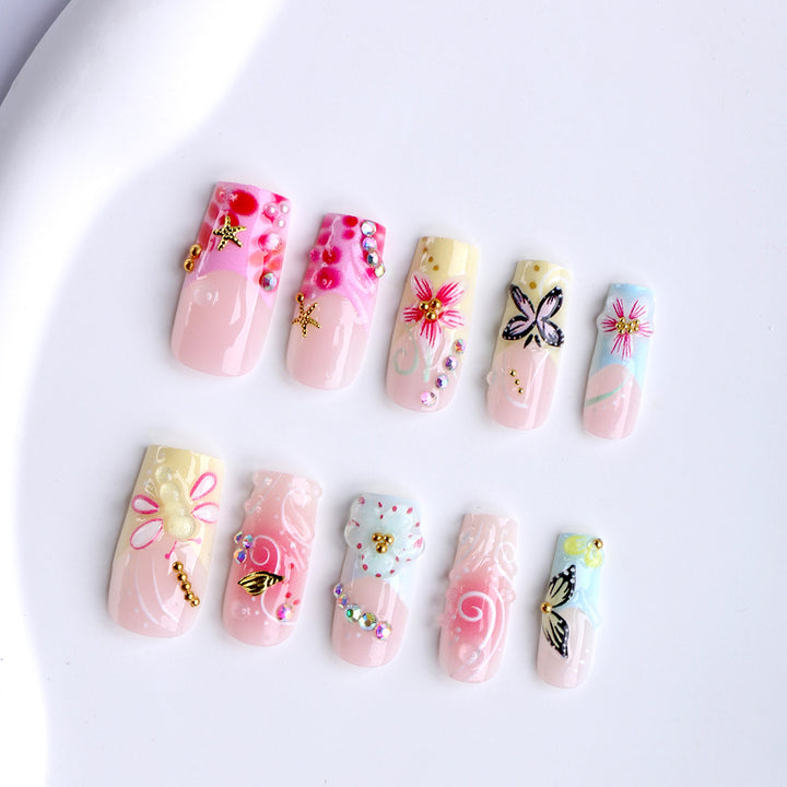 Artistic nails with floral accents and glitter clusters Bowlift