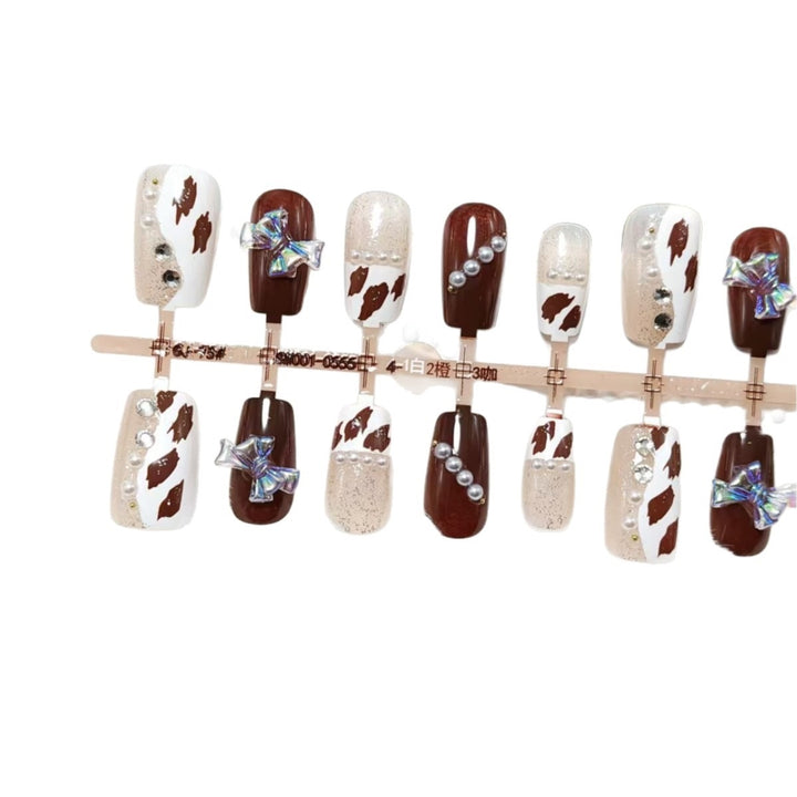 Artificial nails with sparkling rhinestone and bow accents Bowlift