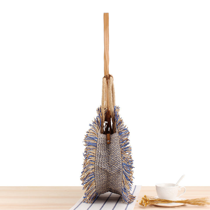 Round bag with fringe decoration Made of woven material Bowlift