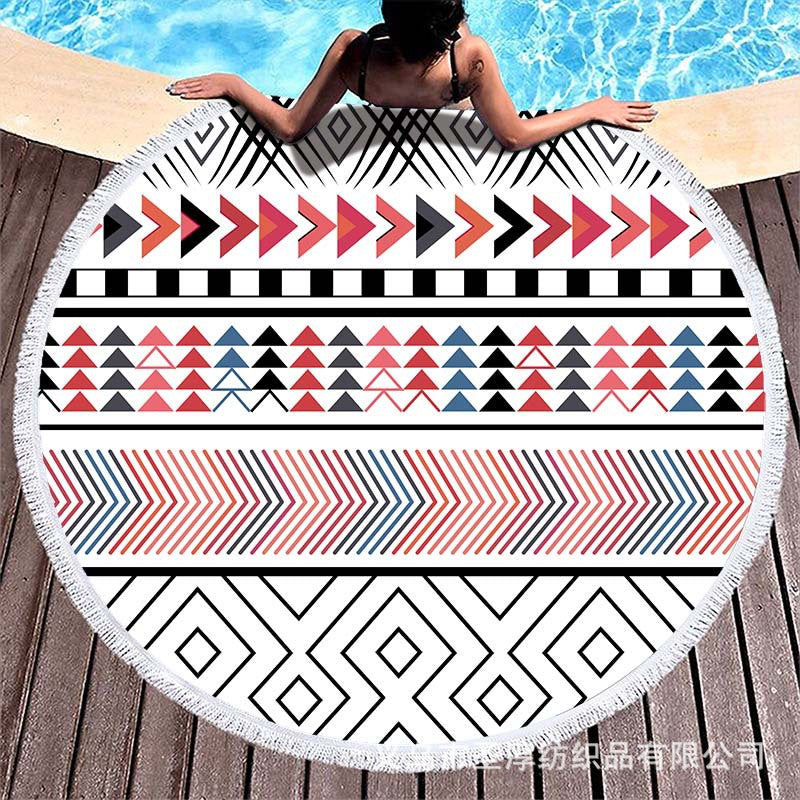 Round beach towel with colorful, tropical floral pattern and fringe decoration Bowlift