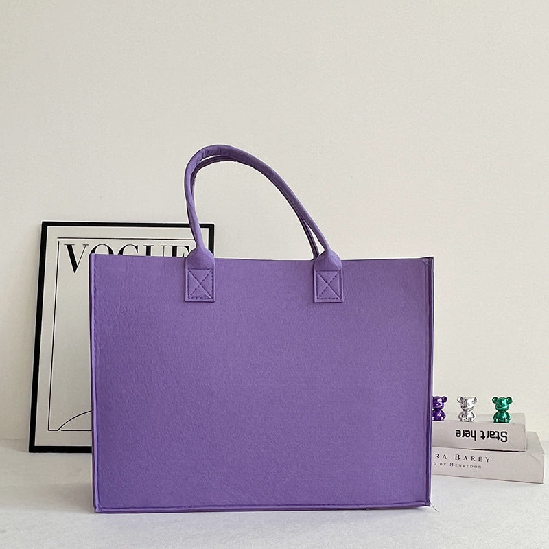 Structured felt tote bag with reinforced handles and organized interior Bowlift