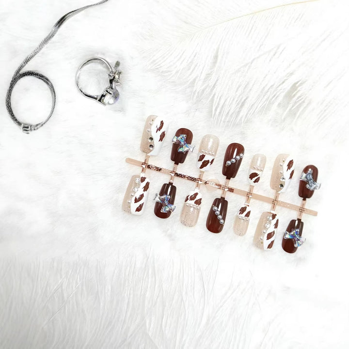 Artificial nails with sparkling rhinestone and bow accents Bowlift