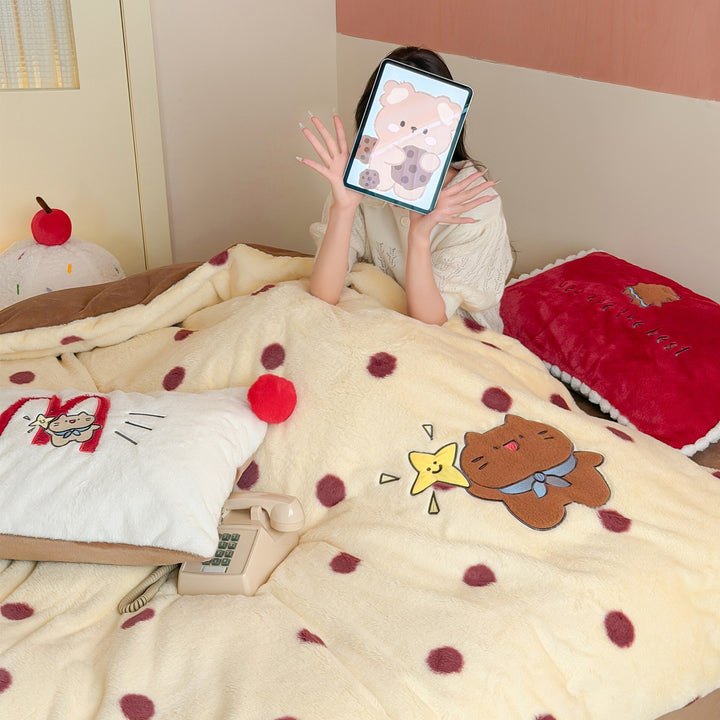 Plush bedspread with embroidered bear motif and pom-pom edge