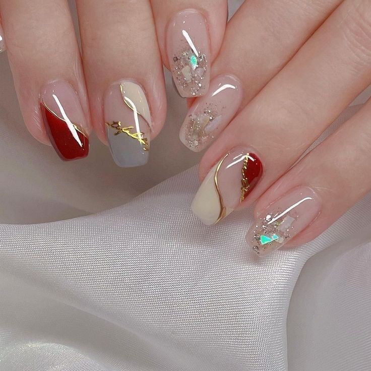 Artificial nails with elegant gold pattern and glitter accents Bowlift