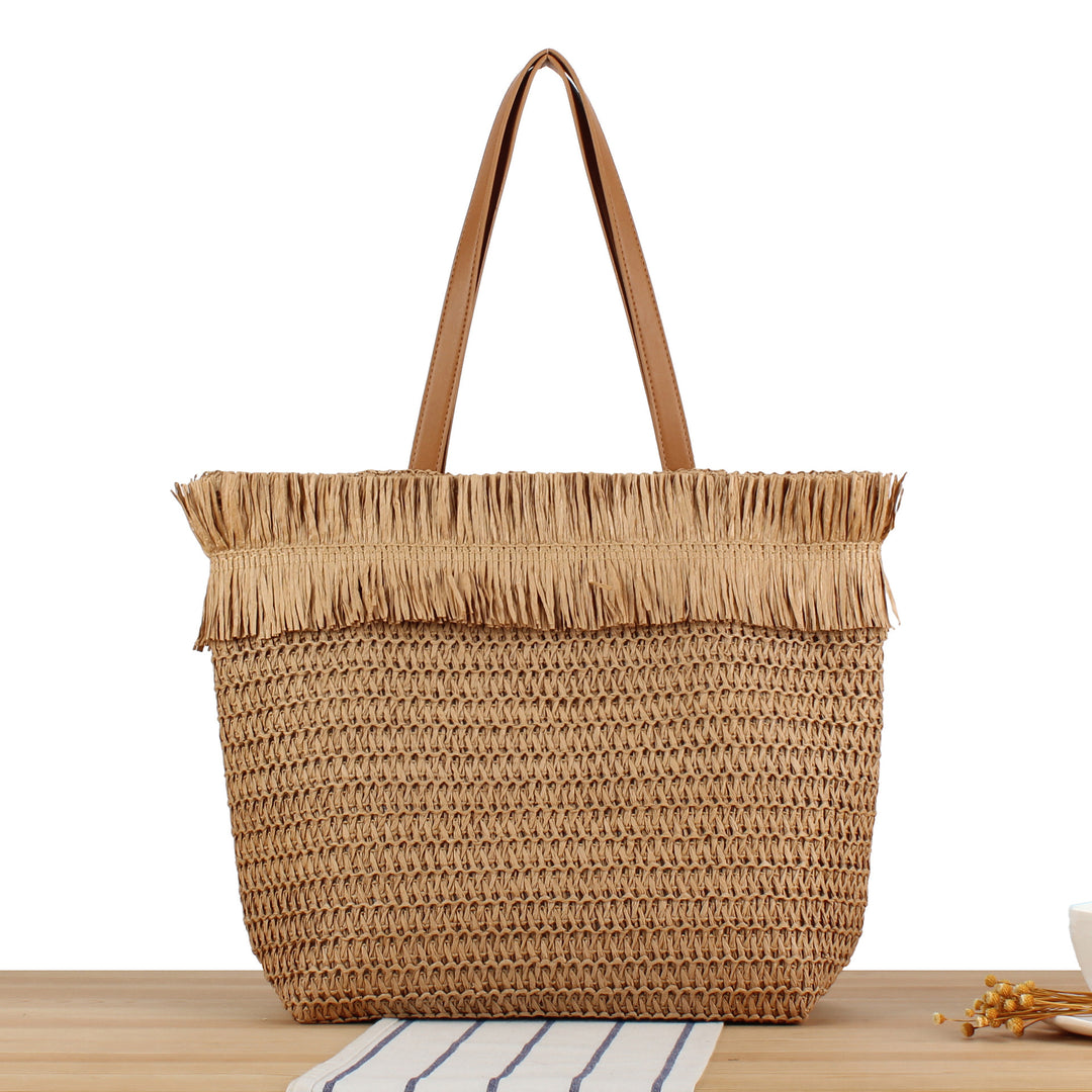 Beach bag made of handwoven natural material with fringe decoration Bowlift