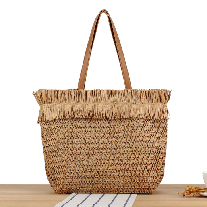 Beach bag made of handwoven natural material with fringe decoration Bowlift