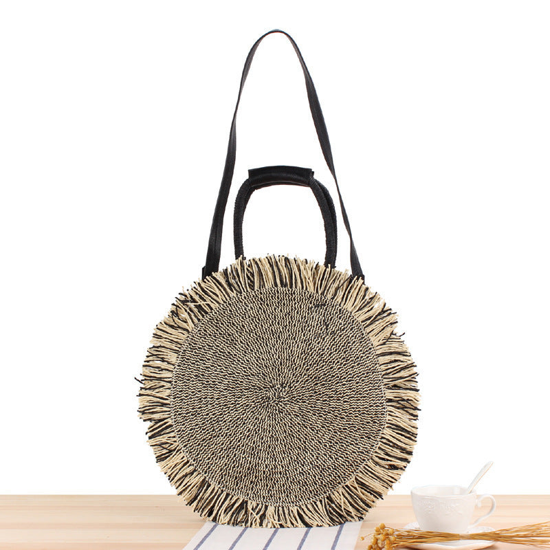 Round bag with fringe decoration Made of woven material Bowlift