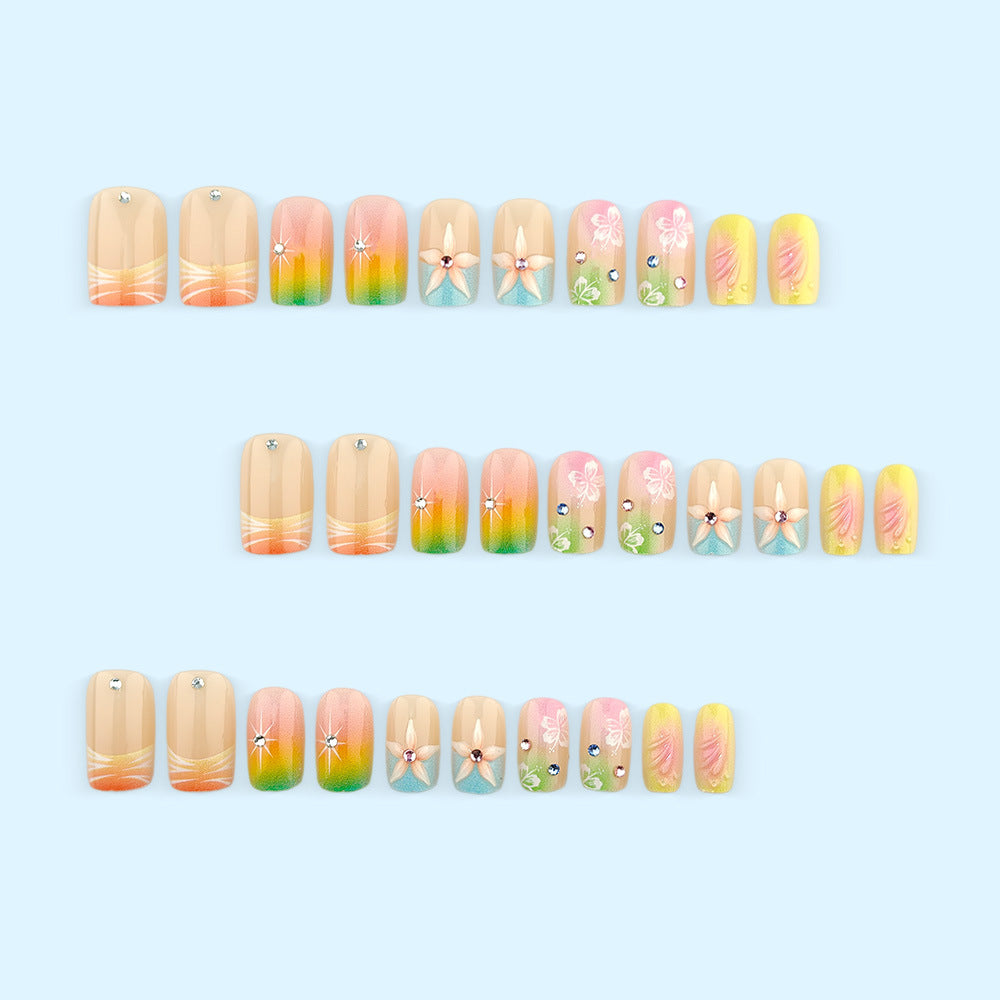 Artificial nails in vibrant floral design with glitter accents Bowlift