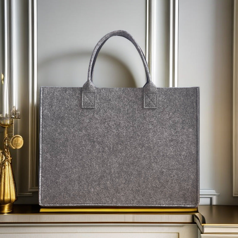 Structured felt tote bag with reinforced handles and organized interior Bowlift