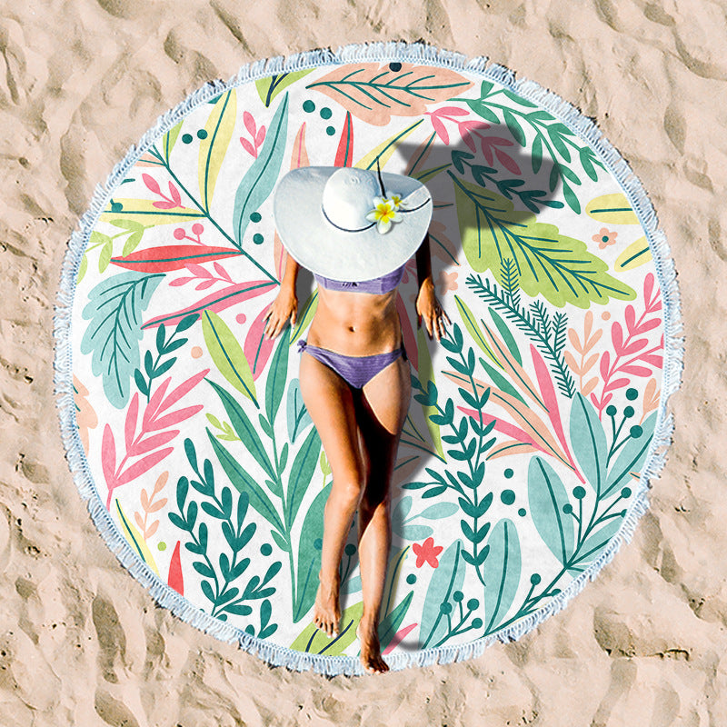 Round beach towel with colorful, tropical floral pattern and fringe decoration Bowlift