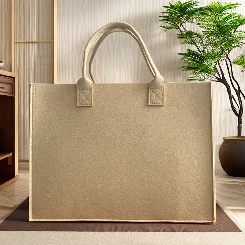 Structured felt tote bag with reinforced handles and organized interior Bowlift